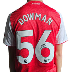 Back view showing Dowman, No. 56, and a visible signature on a red Arsenal football shirt.