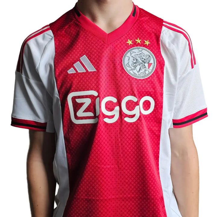 Front view of signed Ajax football shirt featuring Ziggo sponsorship and three stars above the crest.