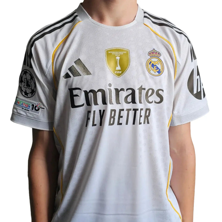 Back view featuring signature, No. 24, and Real Madrid crest with gold trim on a white soccer jersey.