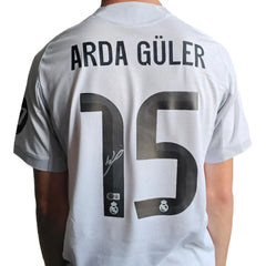 Back view showing Arda Güler, No. 15, and a visible signature on a white football shirt.
