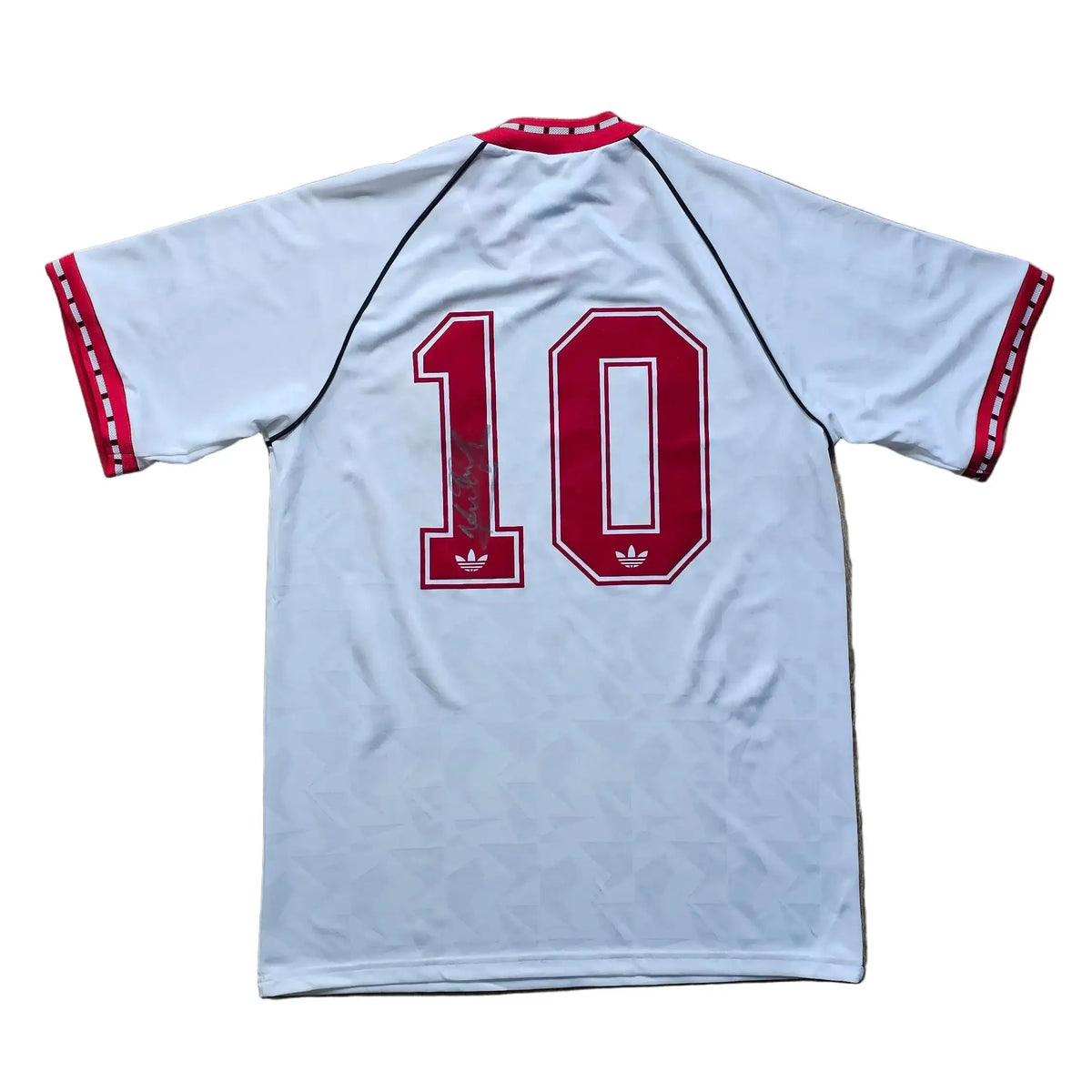 Back of a white Manchester United shirt with red adidas stripes, number 10 in red signed across it, from Mark Hughes's 1990-91 away kit.