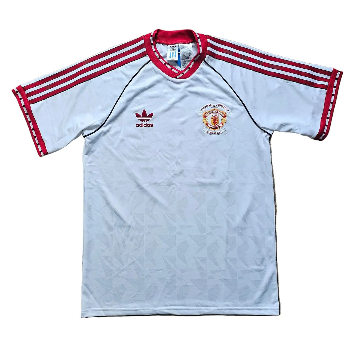Front of the white Manchester United shirt with red adidas stripes and the European Cup Winners' Cup Winners 1991 commemorative crest.