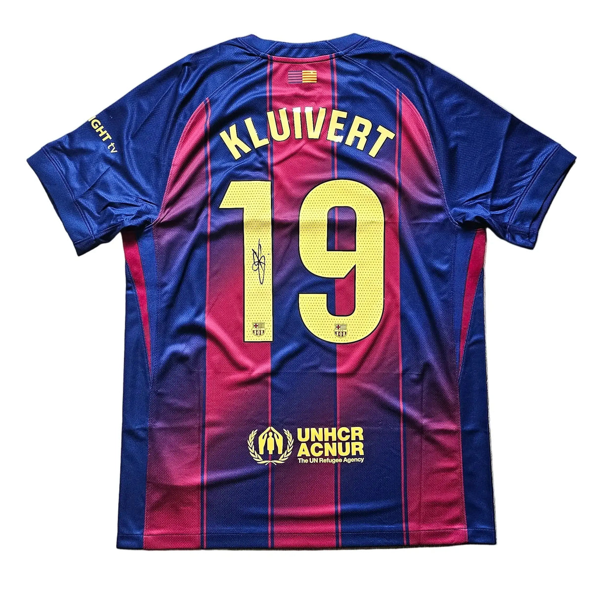 Back view of the No. 19 Kluivert Barcelona shirt with a signature above the number and UNHCR ACNUR branding.