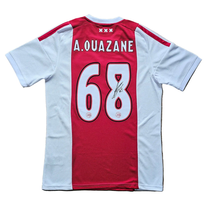 Back of a red-and-white halved Ajax home shirt, A. OUAZANE 68 in white lettering, signed in black marker across the 8.