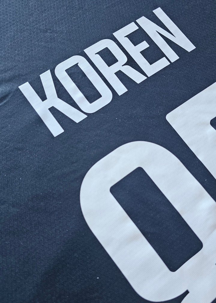 White KOREN name print above the number 85 on the back of the black Club Brugge 2026-27 home shirt