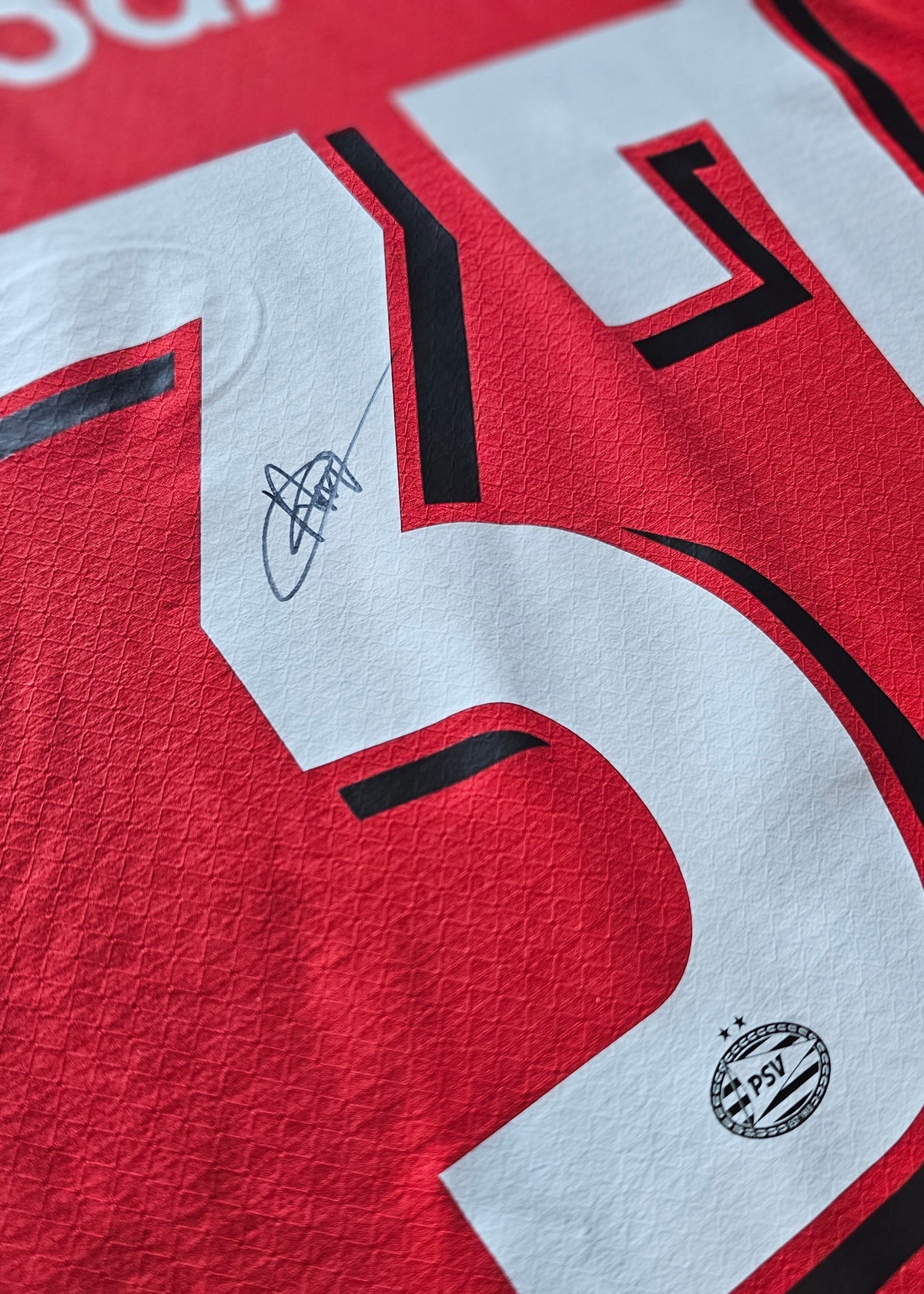 Signed red PSV 2026-27 home shirt, close-up of Amir Bouhamdi's black signature on the 3 of the white number 37
