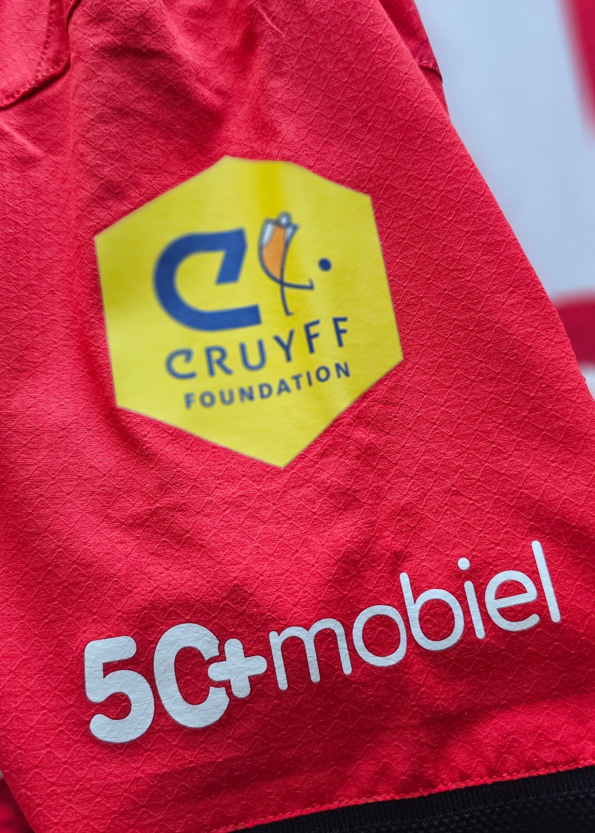 Cruyff Foundation patch and 50+mobiel print on the red sleeve of the Amir Bouhamdi PSV 2026-27 home shirt