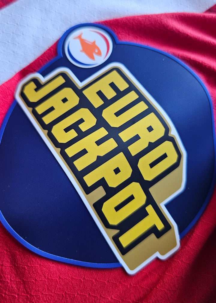 Eurojackpot patch in yellow on navy, with an orange fish emblem, on the red PSV 2026-27 home shirt, Bouhamdi 37
