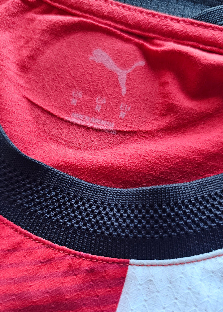 Faded Puma inside neck print, size M, above the black knitted collar of the PSV 2026-27 home shirt, Bouhamdi 37