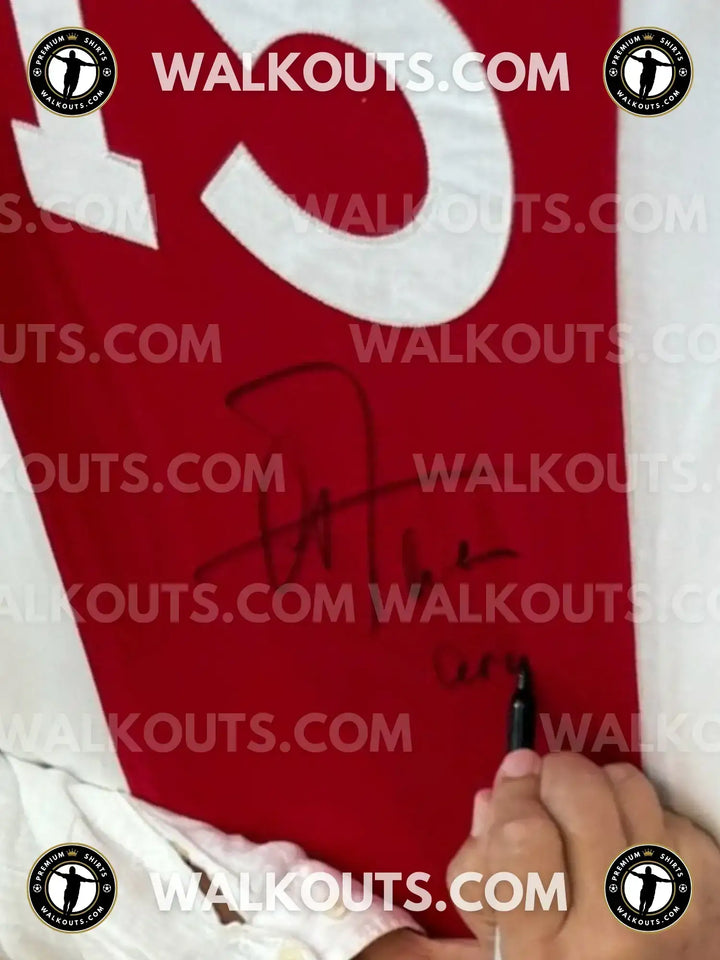 Signature detail on a red Ajax soccer jersey featuring white No. 25.