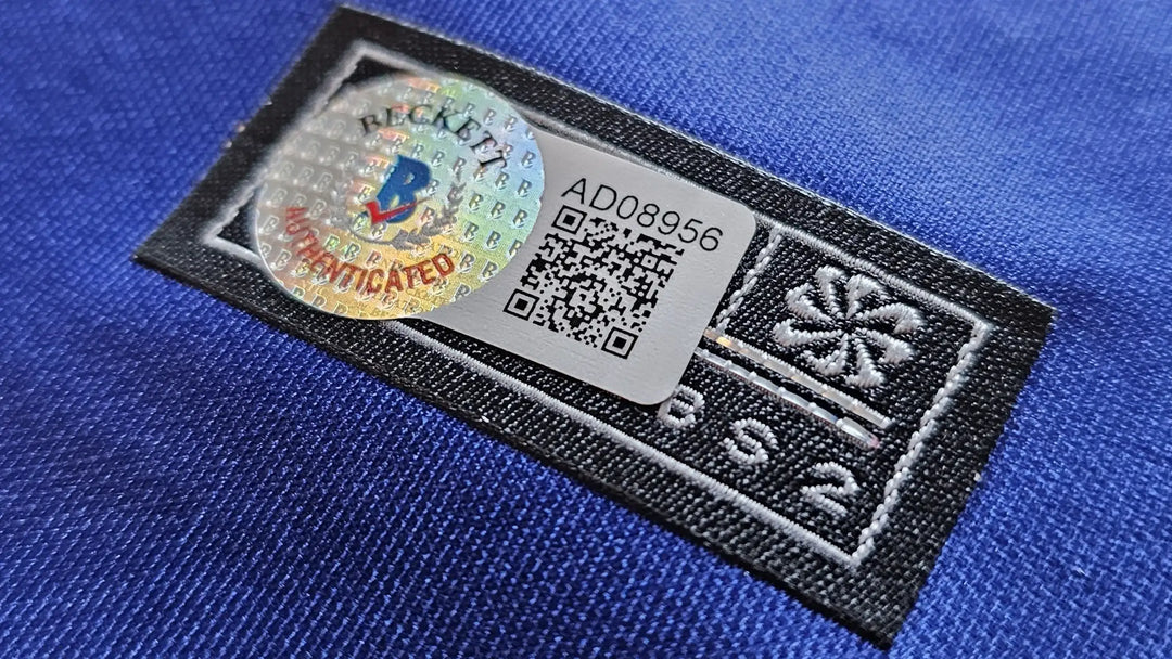 Close-up of Beckett Authenticated hologram and QR label AD08956 affixed to the shirt, showing third-party verification.