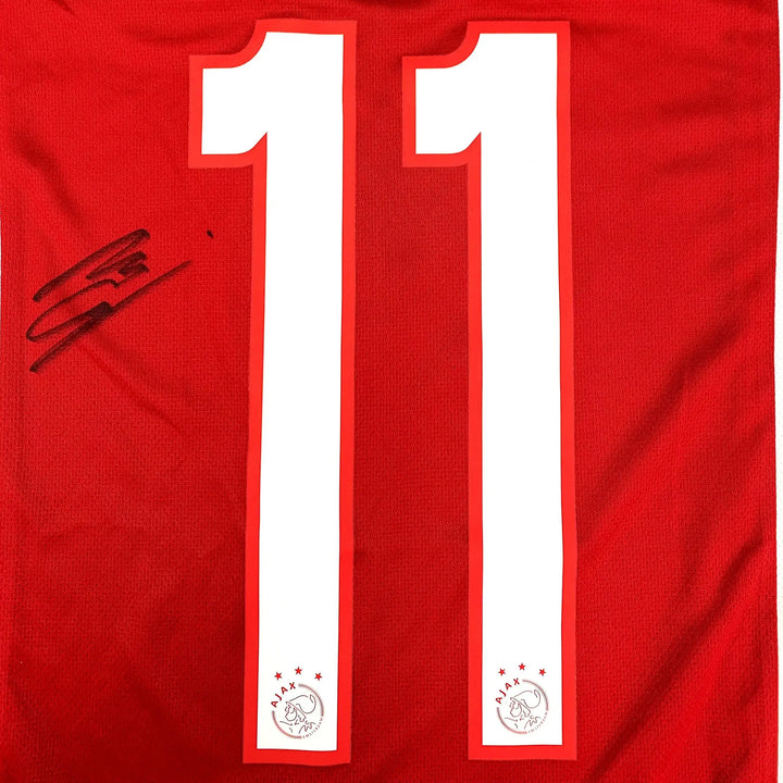 Back view showing No. 11 and signature on a red Ajax football shirt.