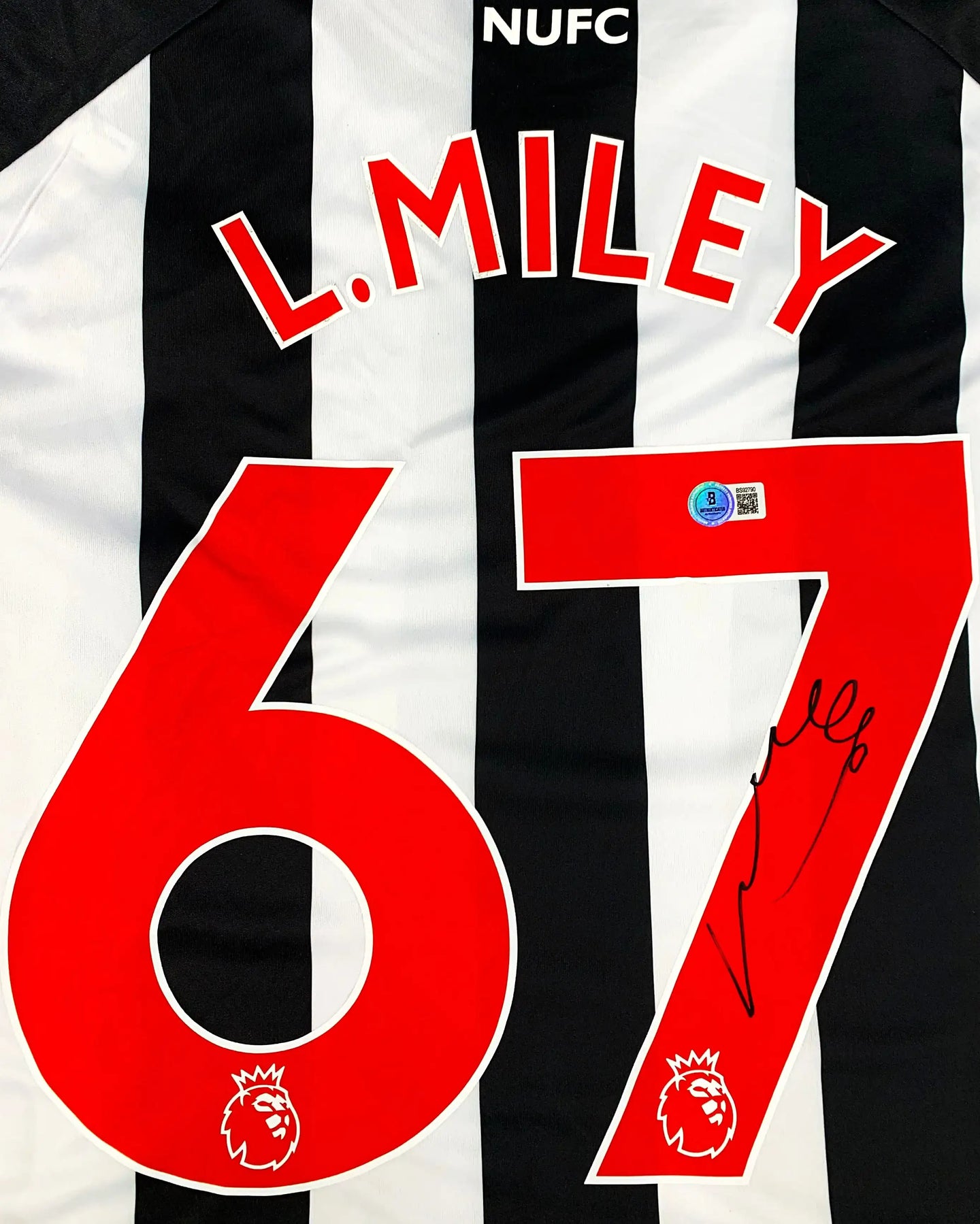 Back view featuring L. Miley, No. 67, and a visible signature on a black and white striped football shirt.