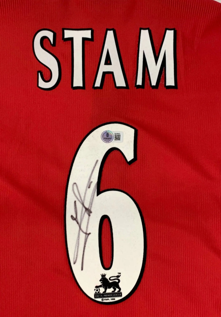 Back view showing STAM, No. 6, and a visible signature on a red football shirt.