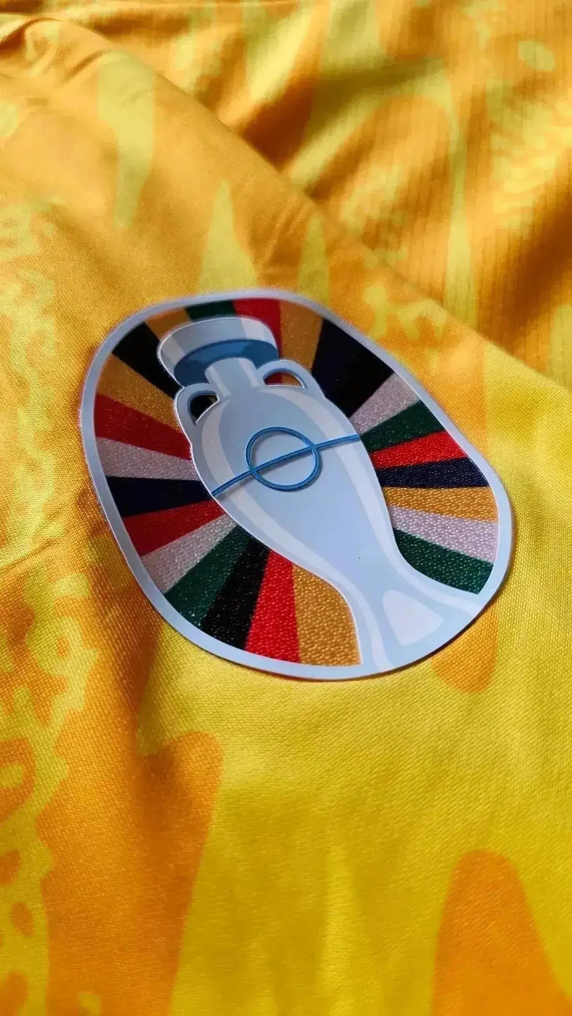 Close-up of the badge on Bart Verbruggen's Holland Euro 2024 match shirt featuring a trophy design.