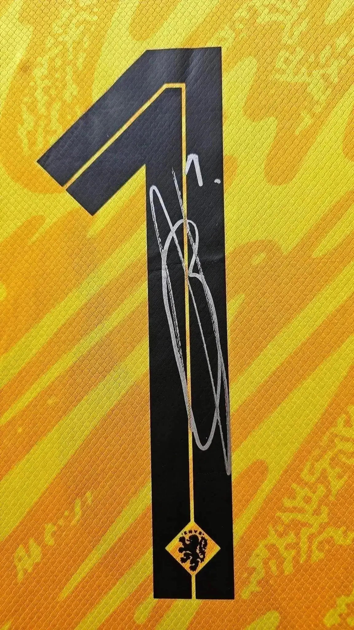 Number 1 on shirt, featuring a visible signature in silver ink.