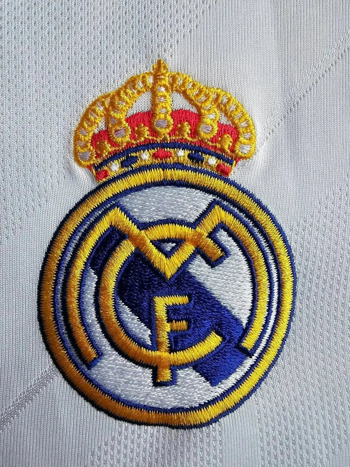 Embroidered Real Madrid crest with crown in gold, blue, and white stitching.