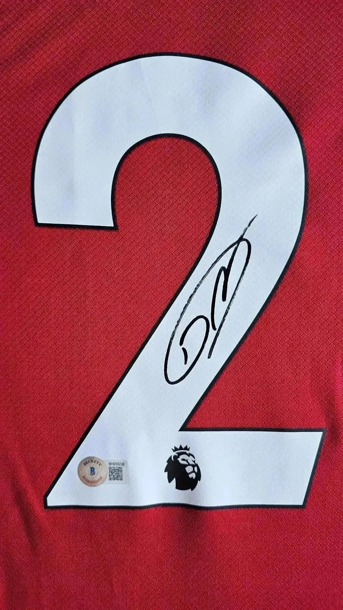 Detail view featuring signature on the No. 2 of a Liverpool F.C. signed soccer jersey.