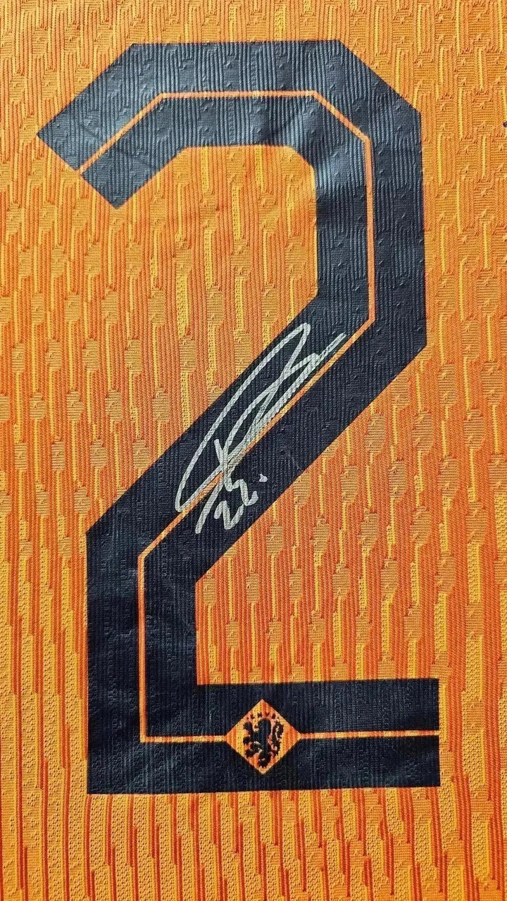 Close-up of No. 22 on an orange football shirt featuring a signature and Holland crest.