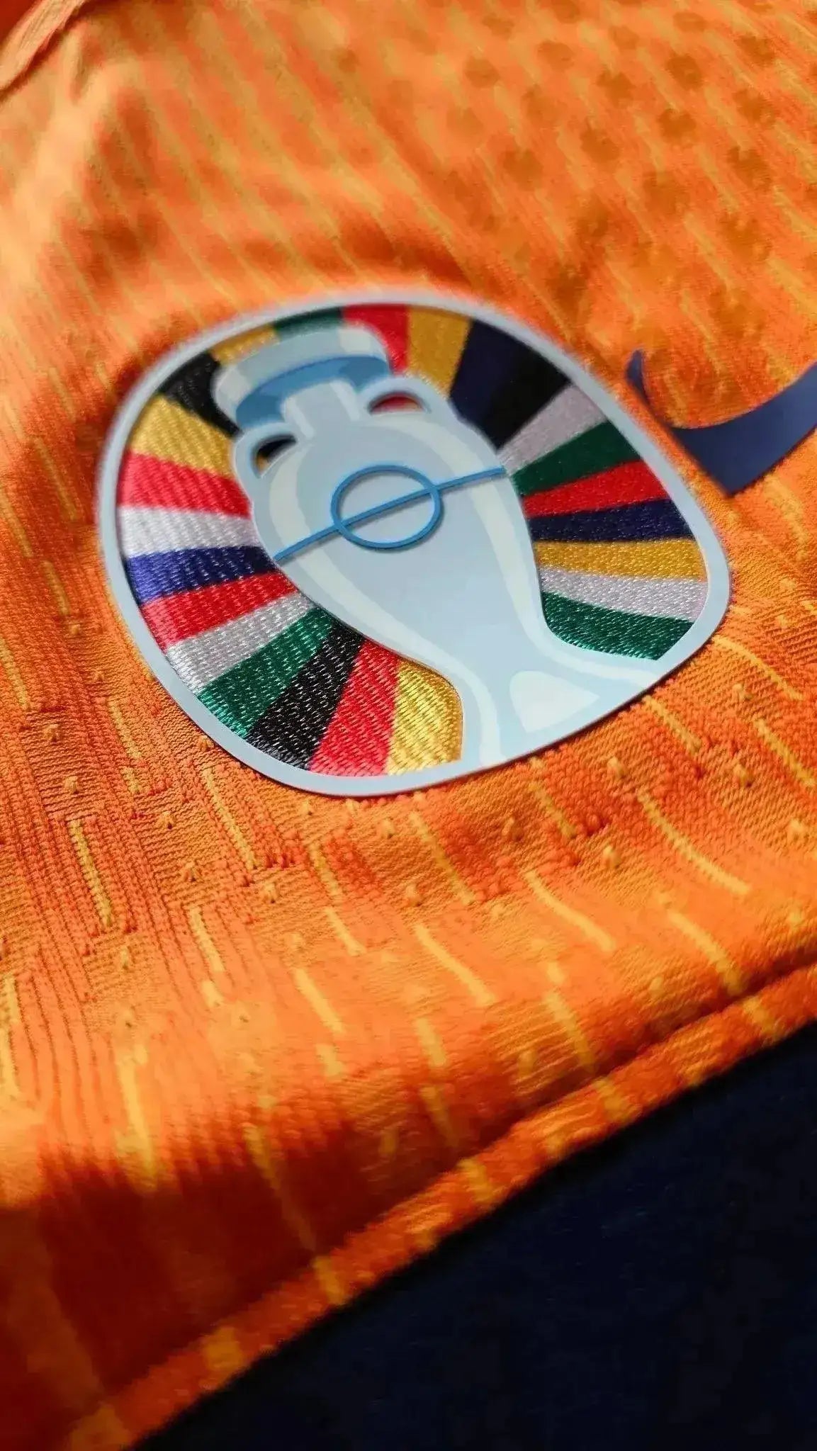 Close-up of Holland Euro 2024 badge in colorful design on an orange football shirt.