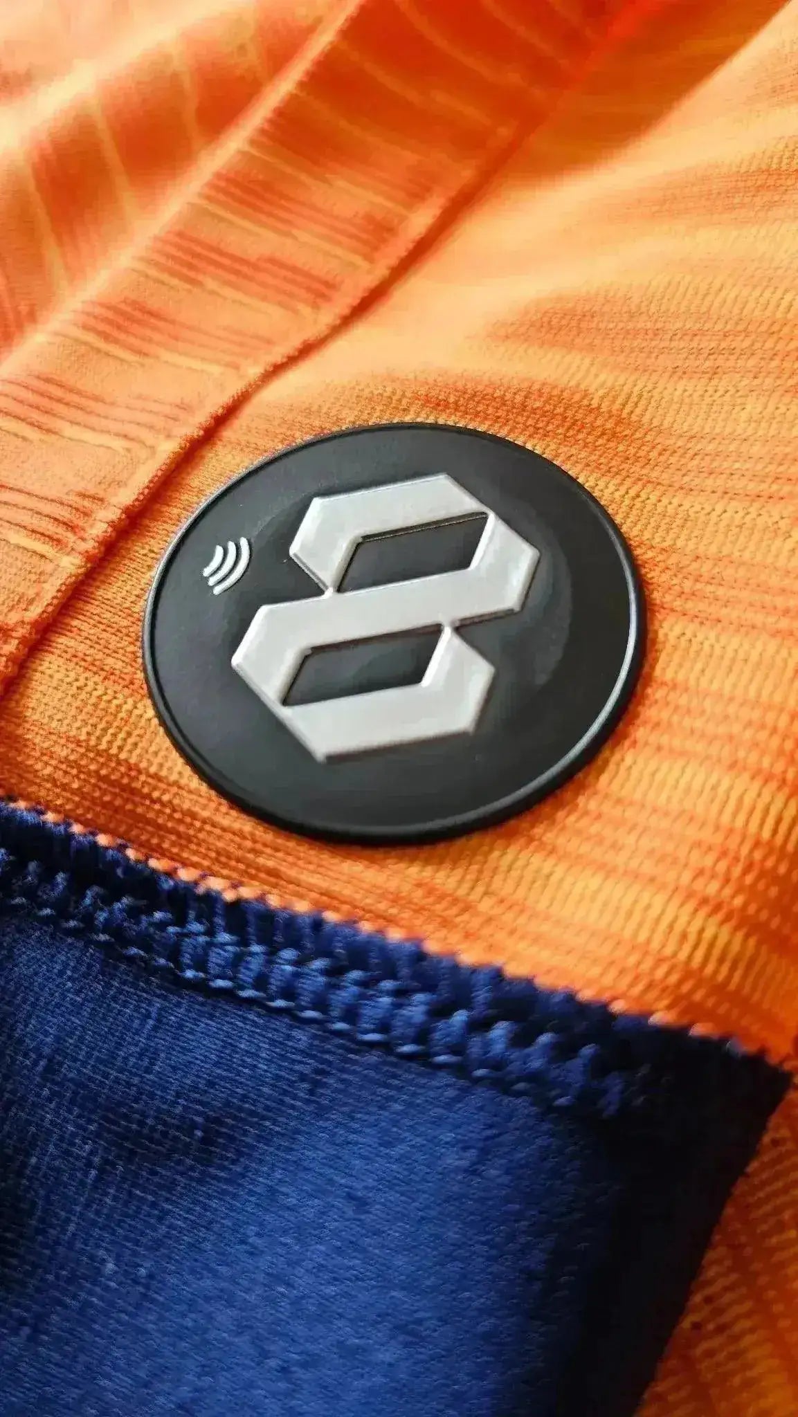 Detail showing the black patch with the number 8 on the orange football shirt.