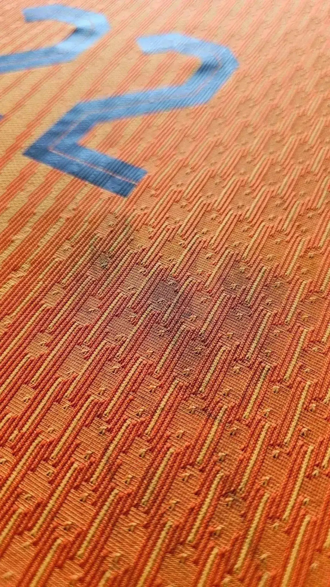 Close-up view of the orange fabric showing No. 22 detailing on a matchworn Holland football shirt.