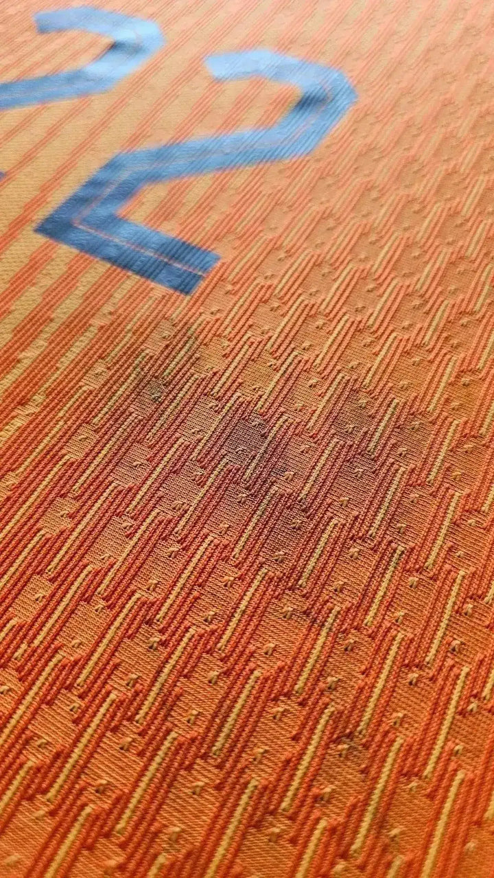 Close-up view of the orange fabric showing No. 22 detailing on a matchworn Holland football shirt.
