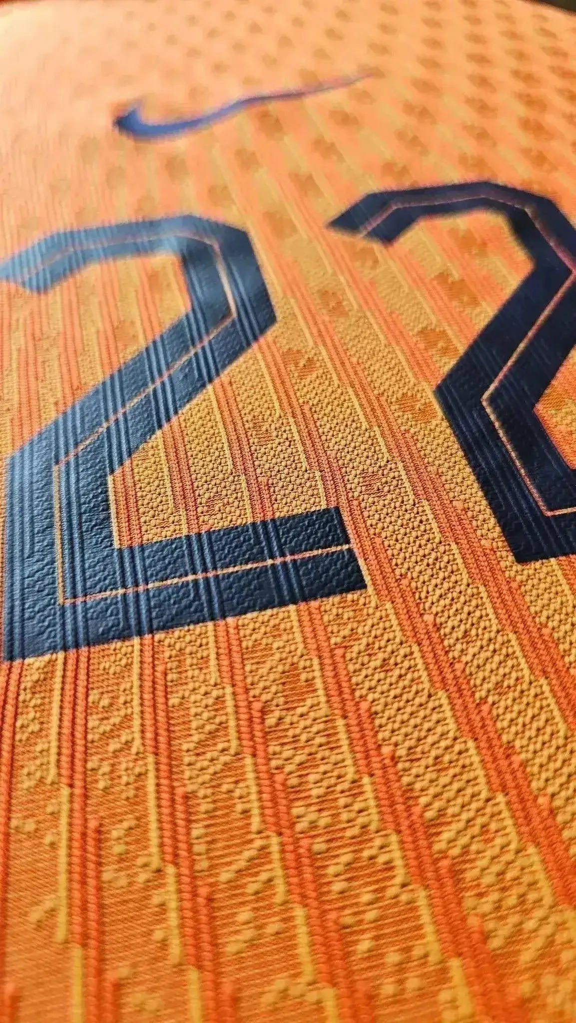 Close-up of No. 22 in black on an orange background, highlighting fabric texture.