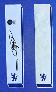 Signature detail displaying Didier Drogba's autograph on white details with Chelsea crest.
