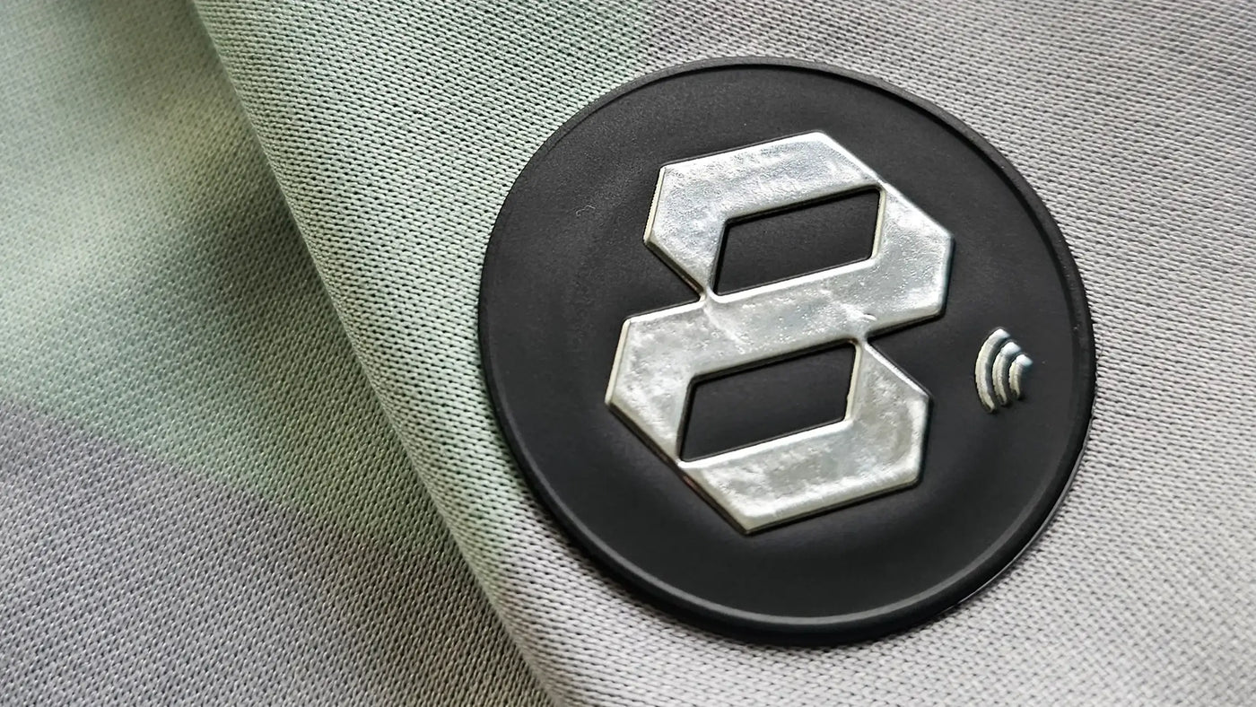 Close-up of a circular Fabricks logo with a stylized number '8' on a textured surface.