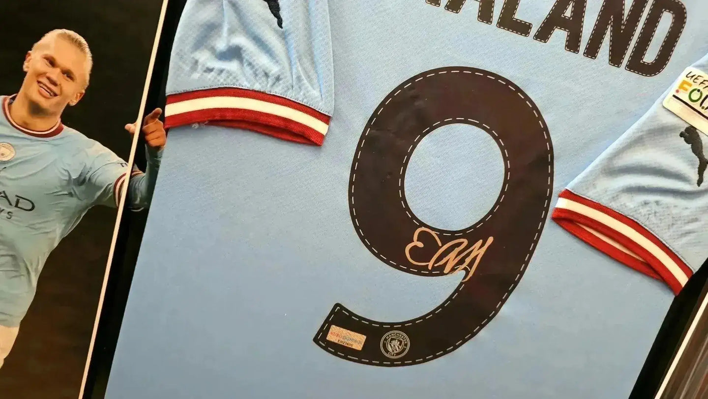 Detail showing No. 9 and signature of Erling Haaland on a Manchester City soccer jersey.