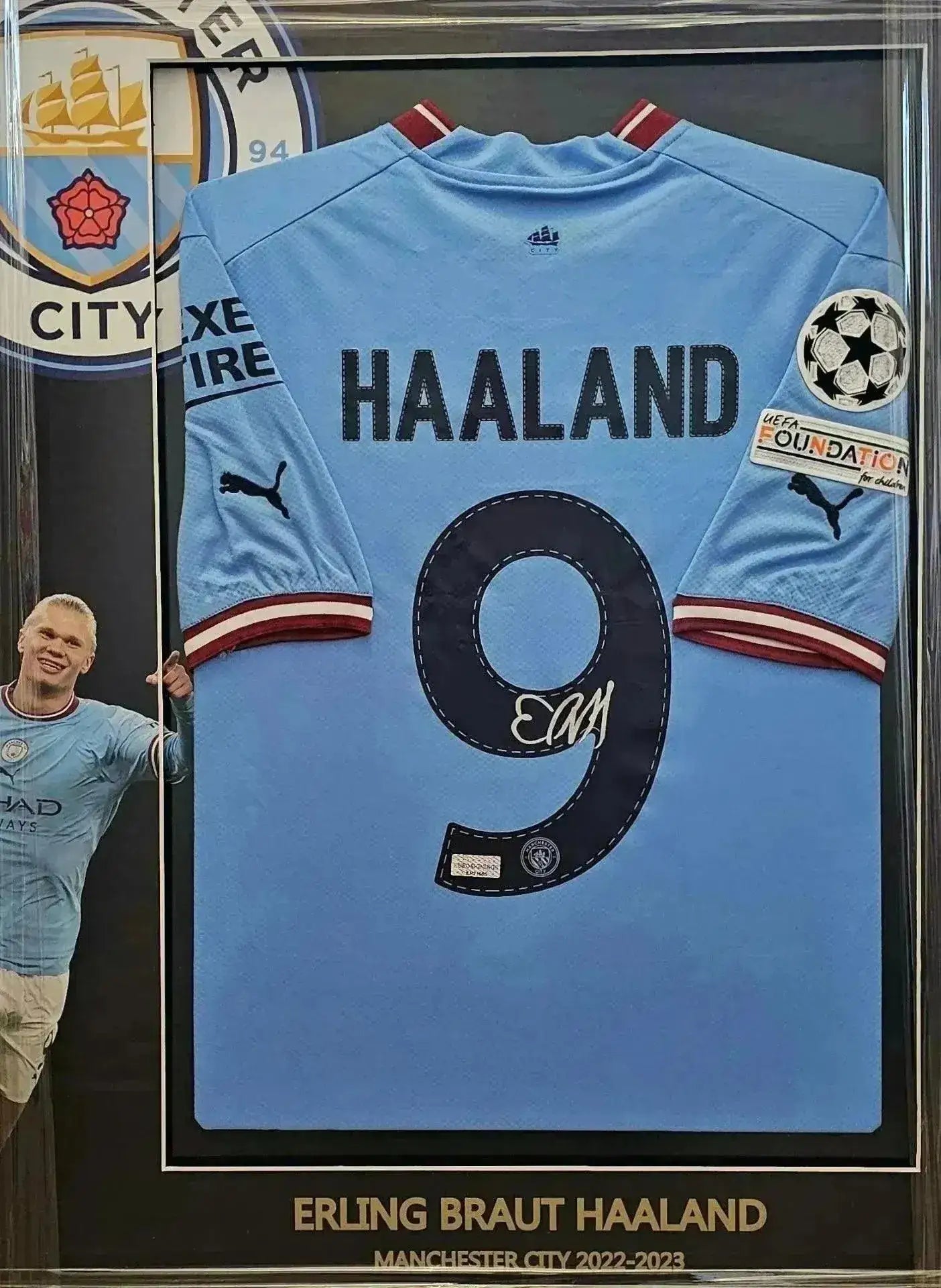 Back view showing Haaland, No. 9, and signature in a frame with Manchester City crest.