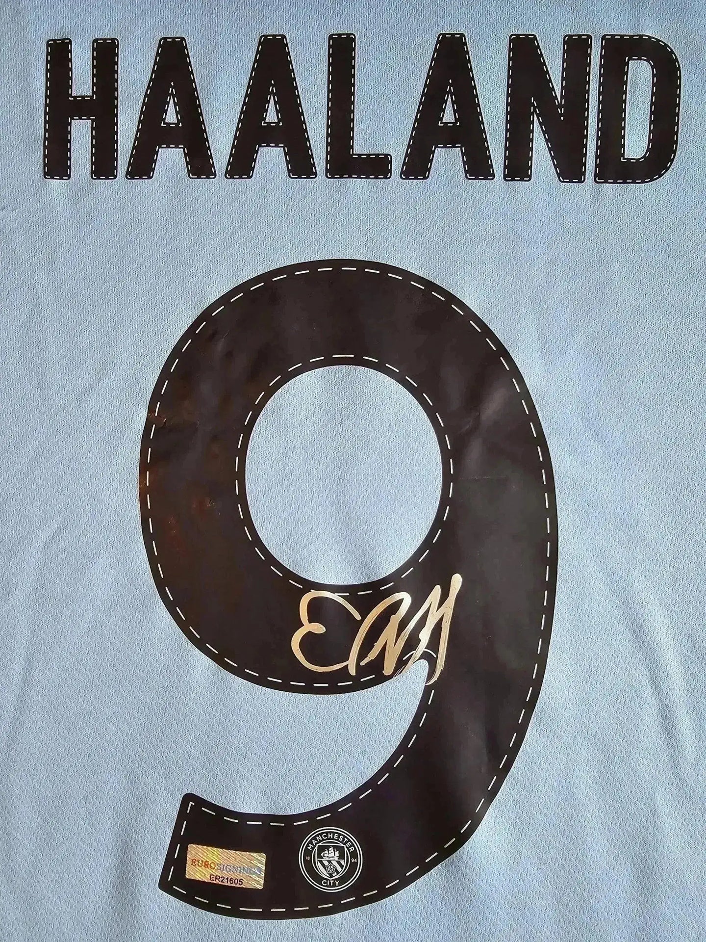 Back view showing HAALAND, No. 9, and an elegant signature on the Manchester City soccer jersey.