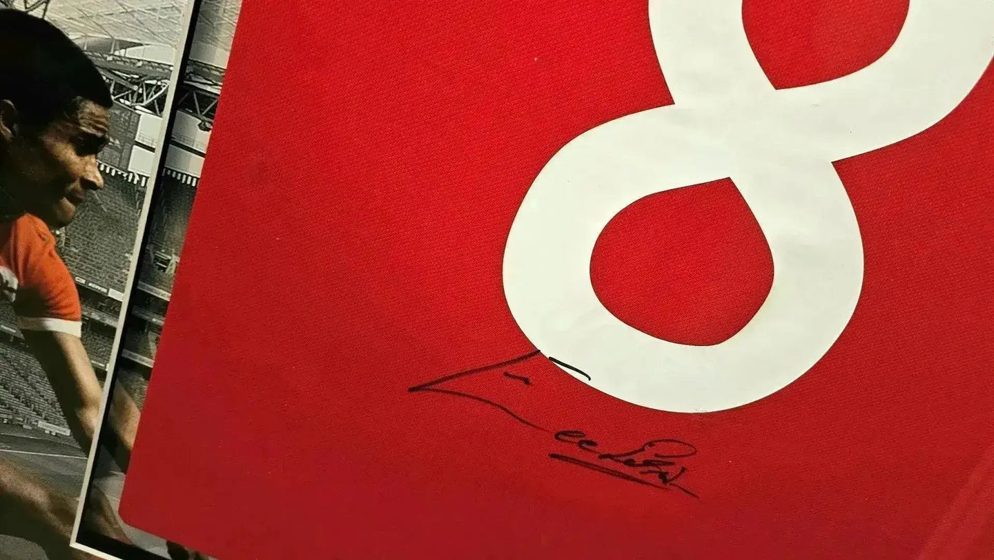Close-up of No. 8 on red shirt with signature of Eusébio below the number.