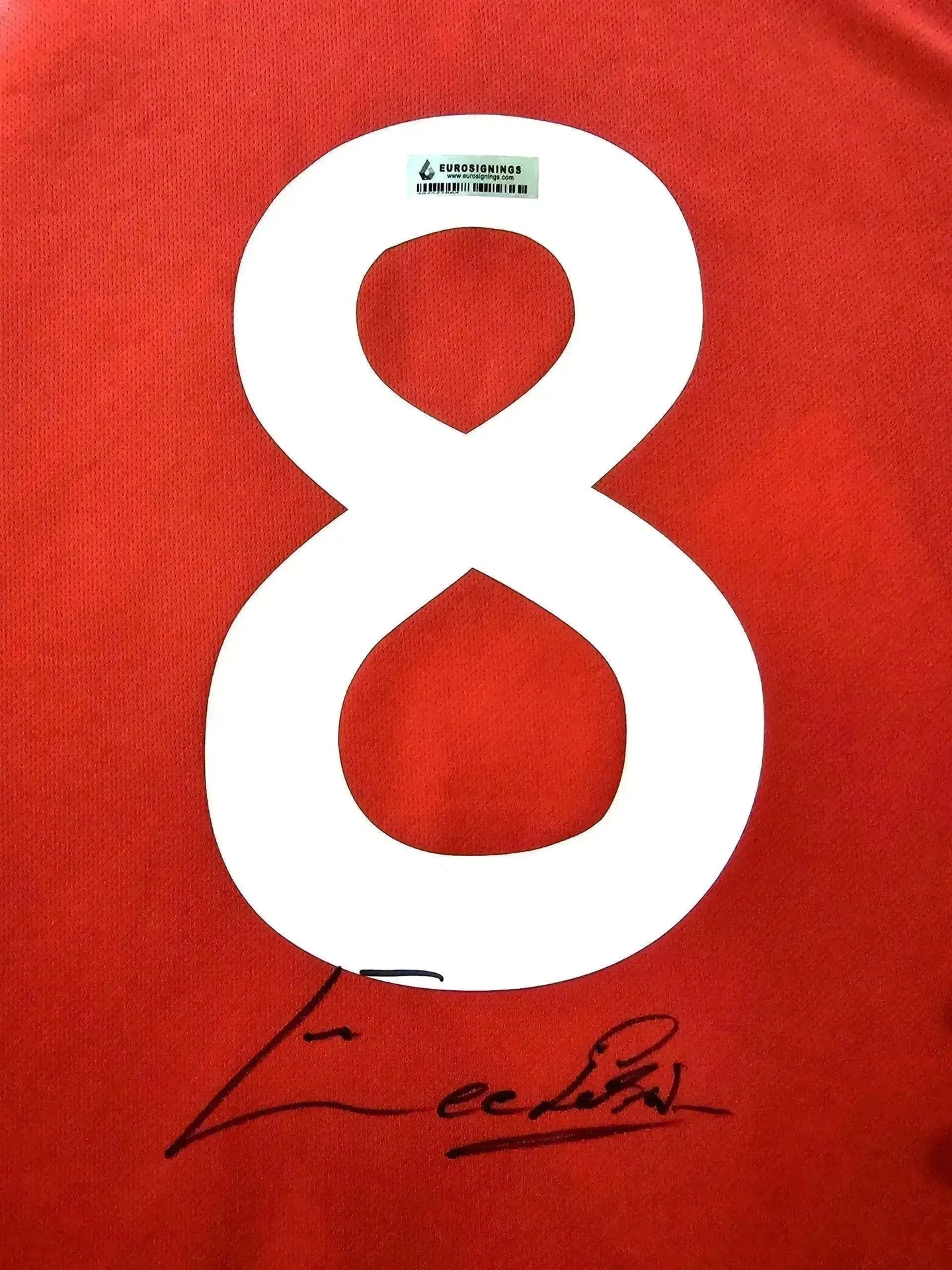 Back view showing No. 8 and Eusébio's signature on a red soccer jersey.