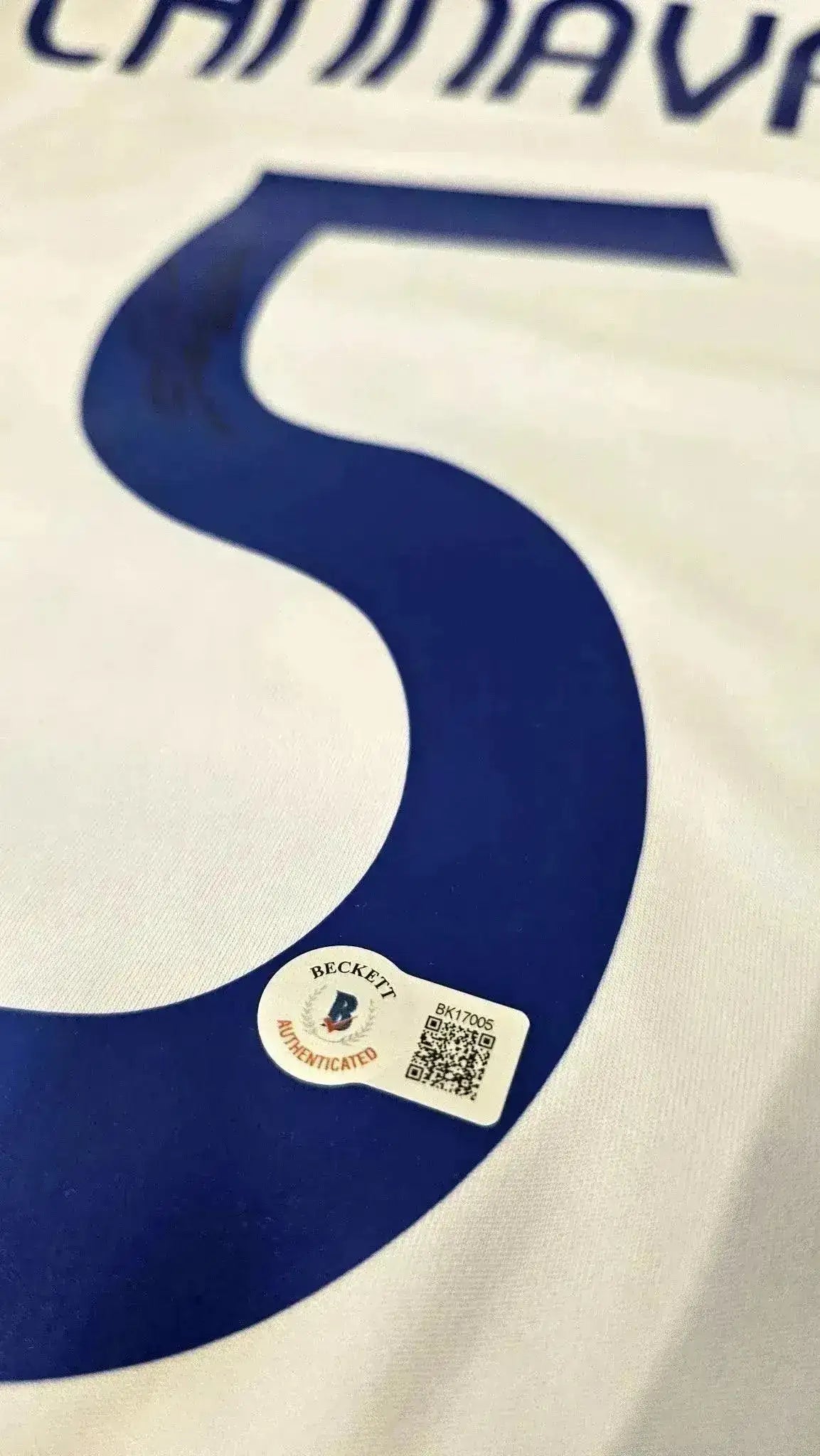 Detail showing signature and No. 5 with Beckett authentication on the soccer jersey.