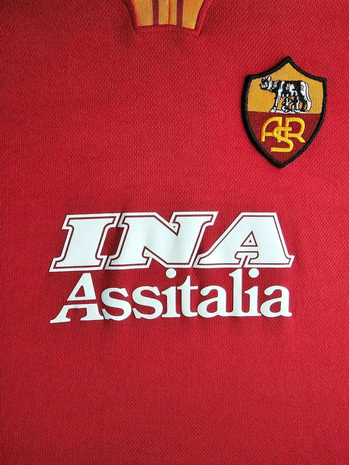 Detail view showing A.S. Roma crest and INA Assitalia sponsor on red soccer jersey.
