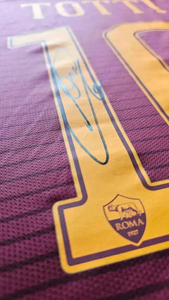 Close-up of shirt detail showing No. 10, name 'TOTTI', and signature on A.S. Roma shirt.