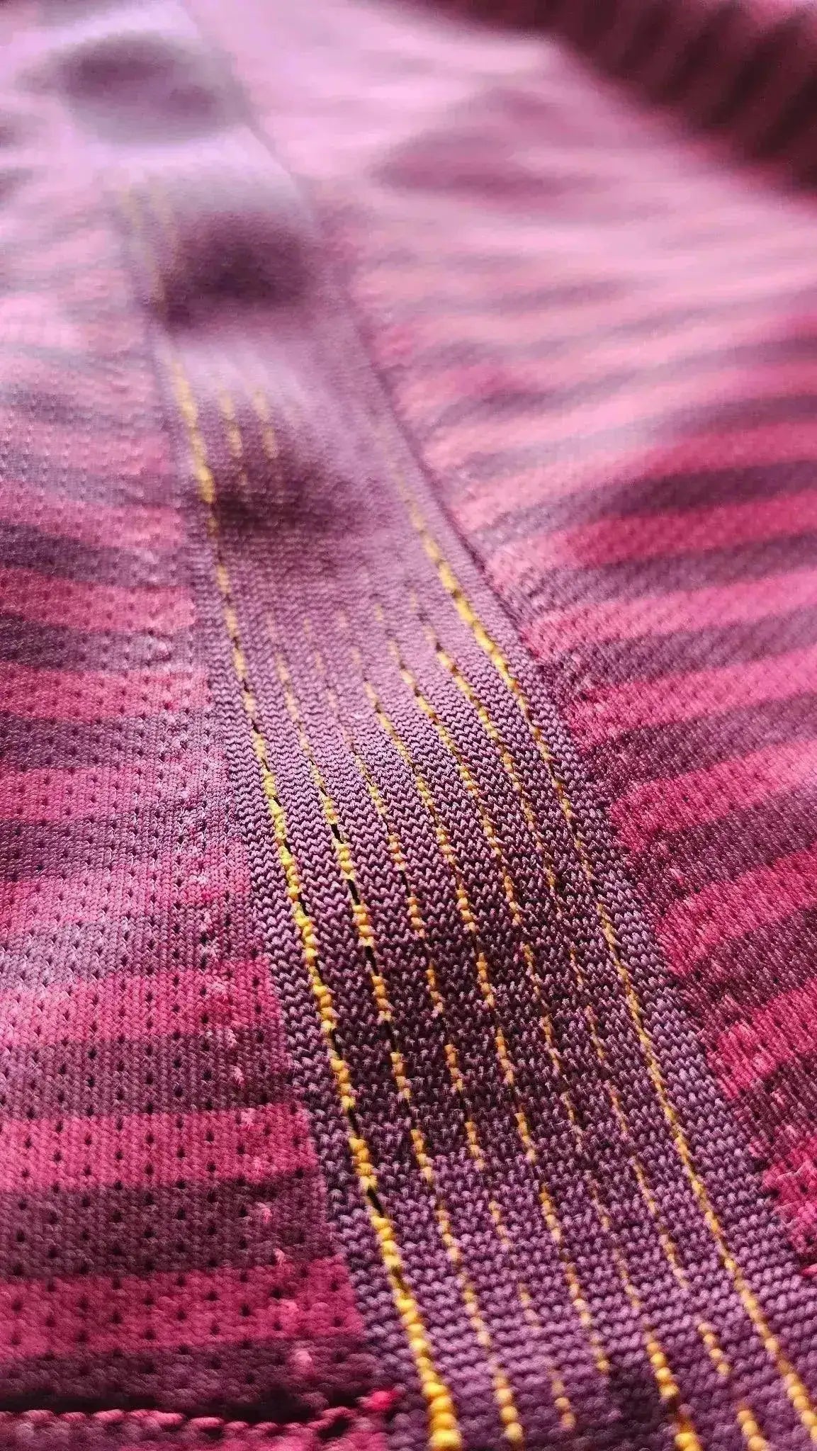 Close-up detail highlighting the textured fabric and stitch patterns of the football shirt.