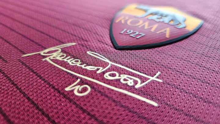 Close-up detail featuring the A.S. Roma crest, signature of Francesco Totti, and No. 10.