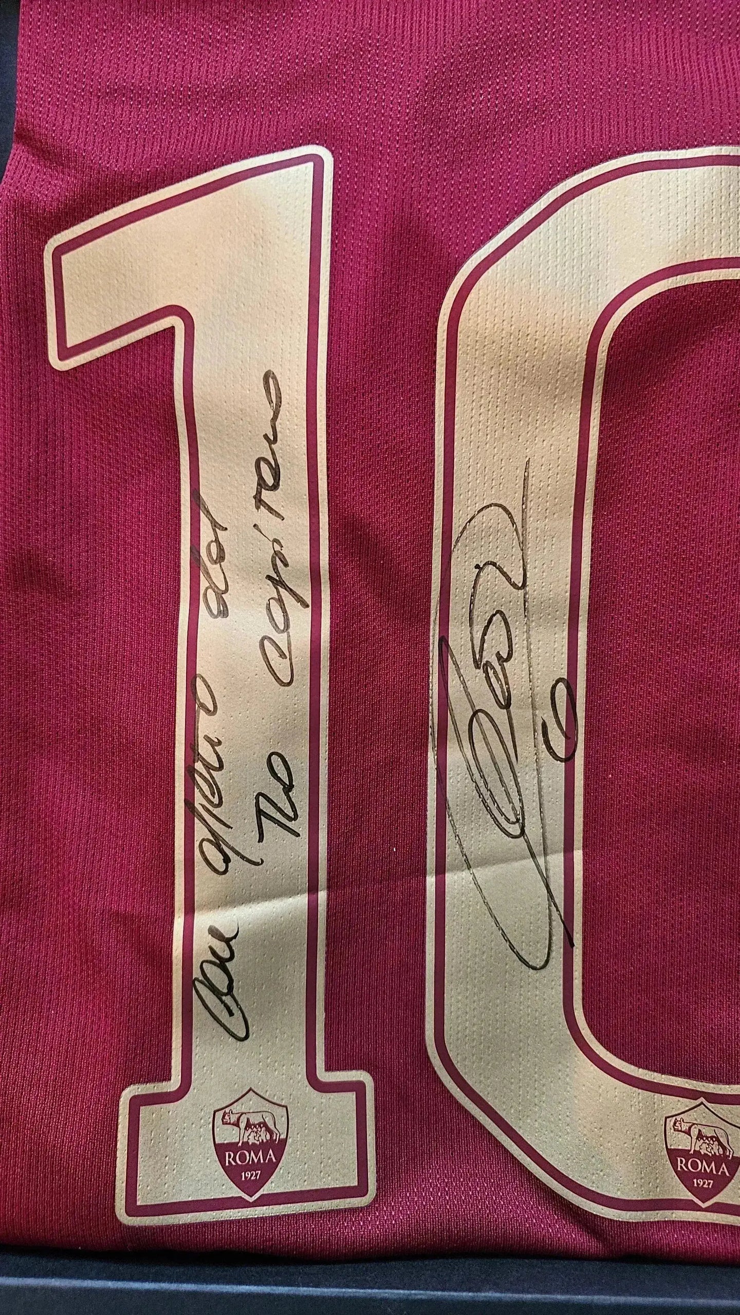 Close-up of No. 10 shirt with signatures, featuring the A.S. Roma crest at the bottom.