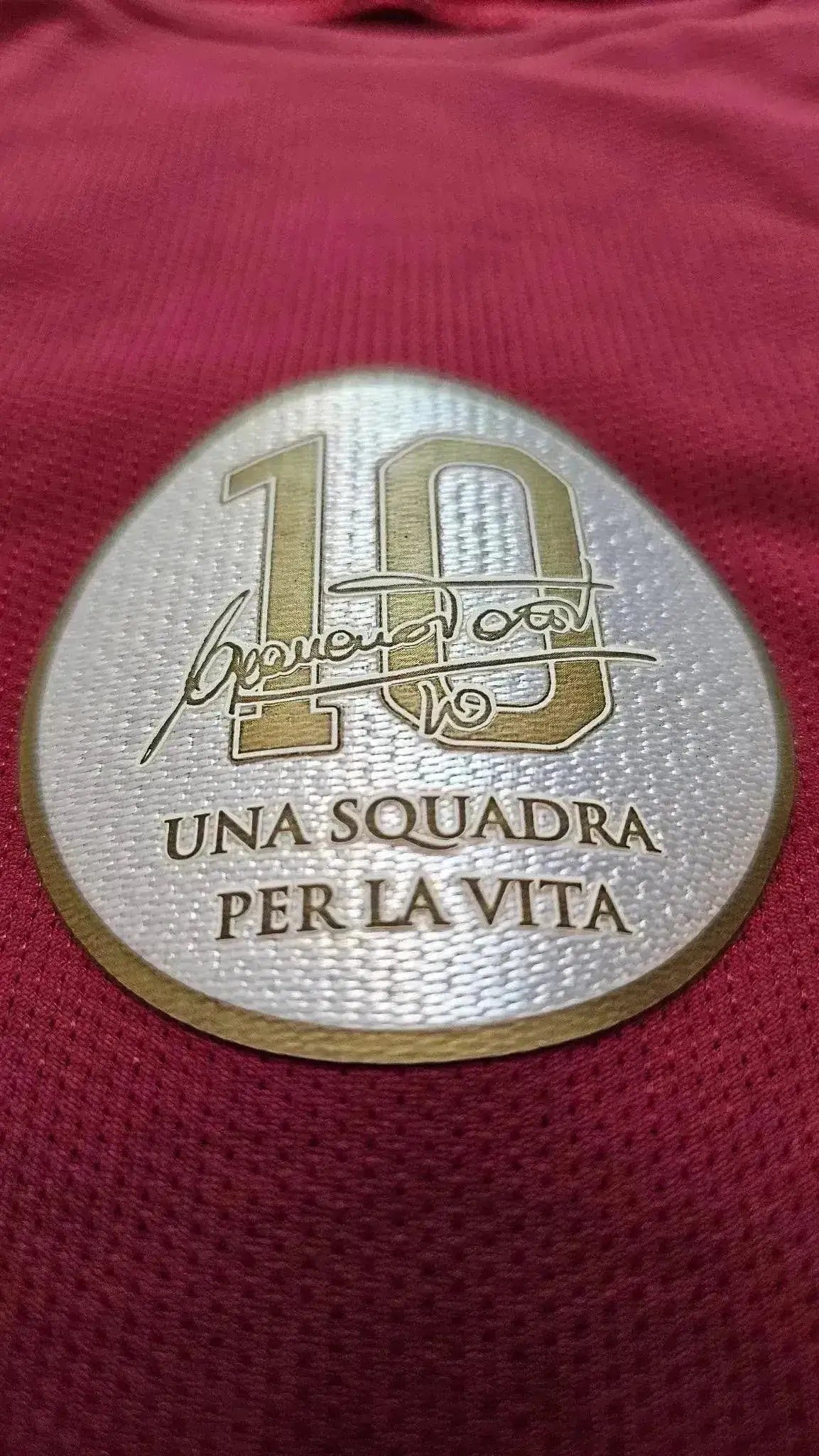Crest detail featuring No. 10, Francesco Totti's signature, and text 'UNA SQUADRA PER LA VITA.'