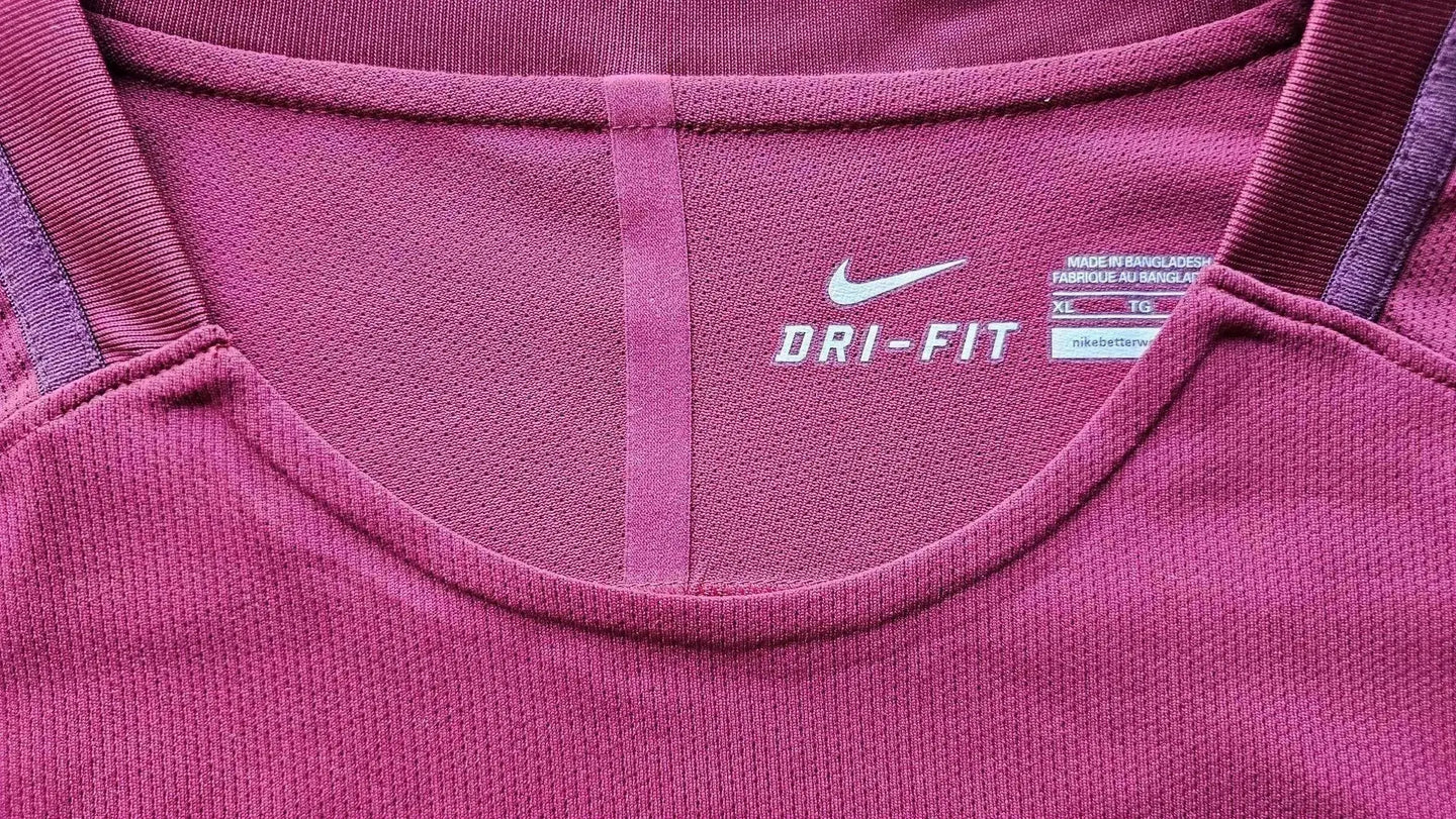 Close-up view showing DRI-FIT label and tag details on pink football shirt.