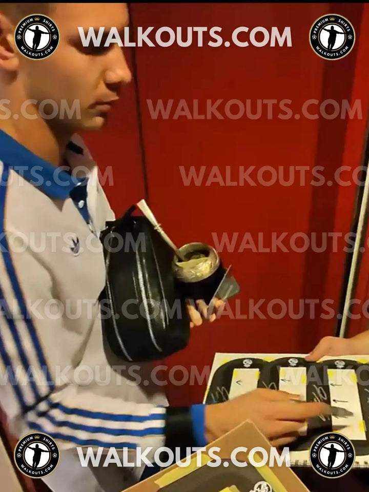 Franco Mastantuono holding a signed football shirt and examining signature details.