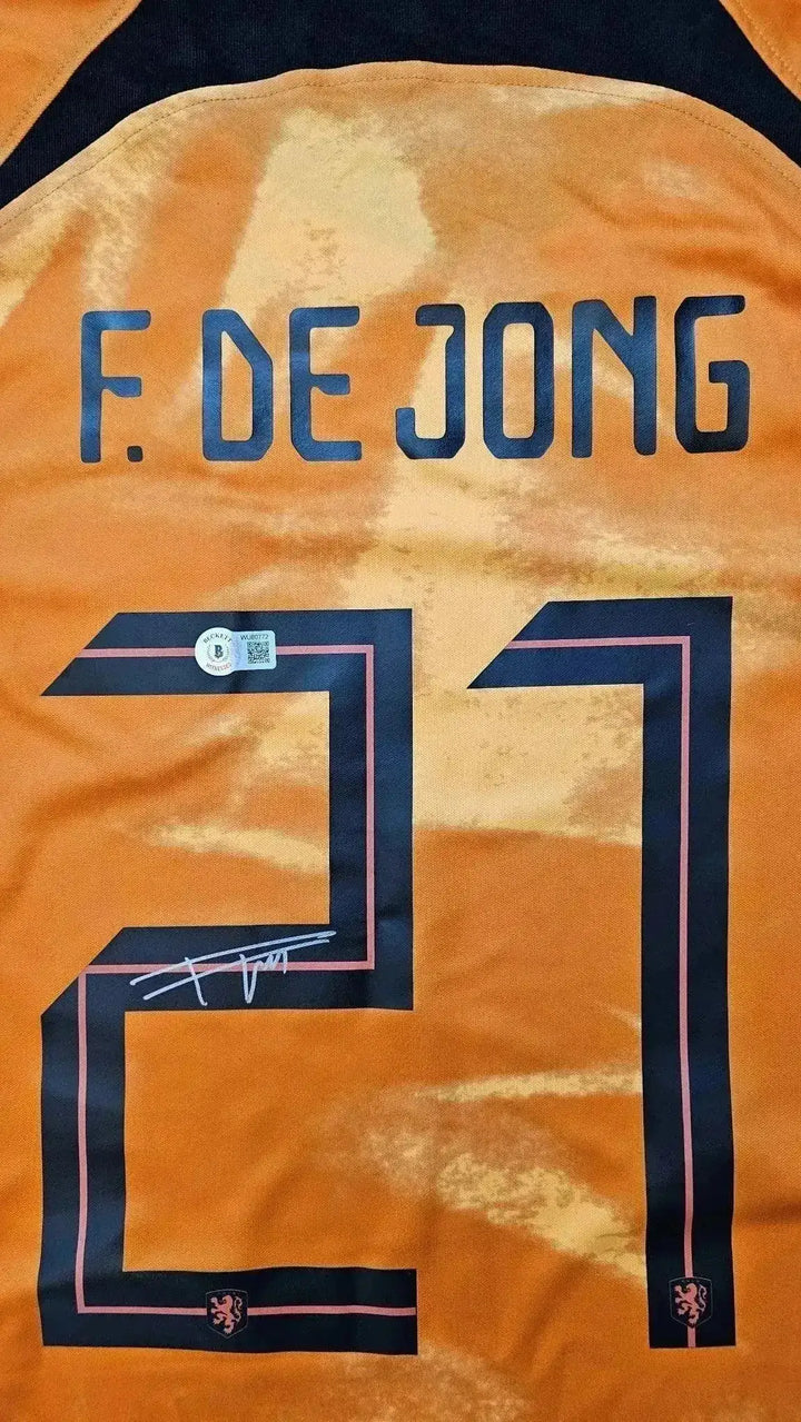 Back view showing No. 21, F. DE JONG, and a visible signature on the orange football shirt.