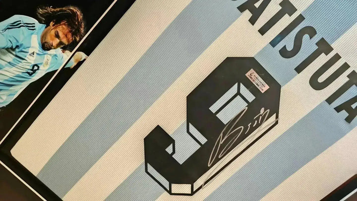 Signature detail featuring No. 9 and Batistuta on a blue and white striped soccer jersey.