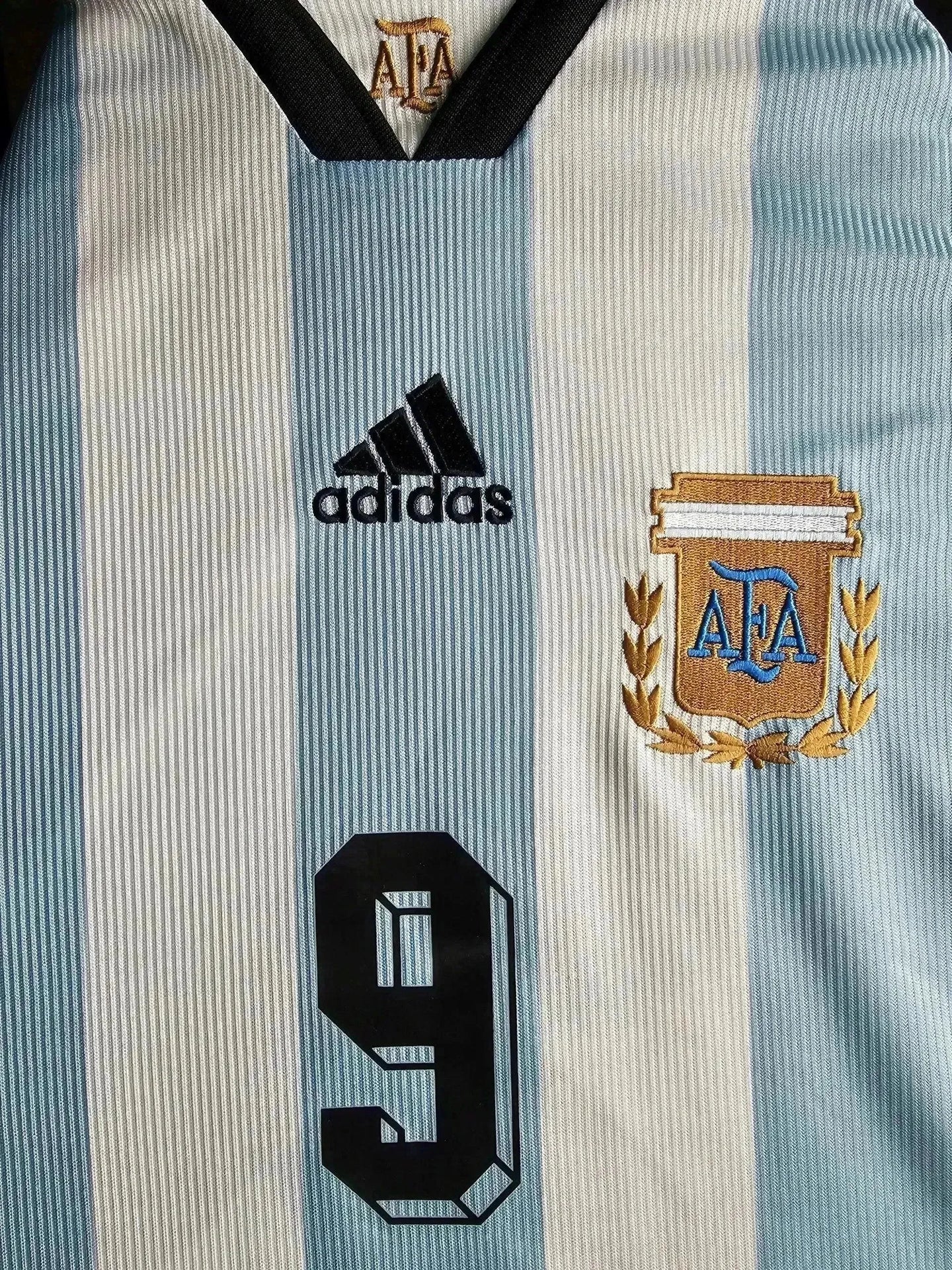 Front view of signed Argentina soccer jersey with AFA crest, black number 9, and adidas logo.