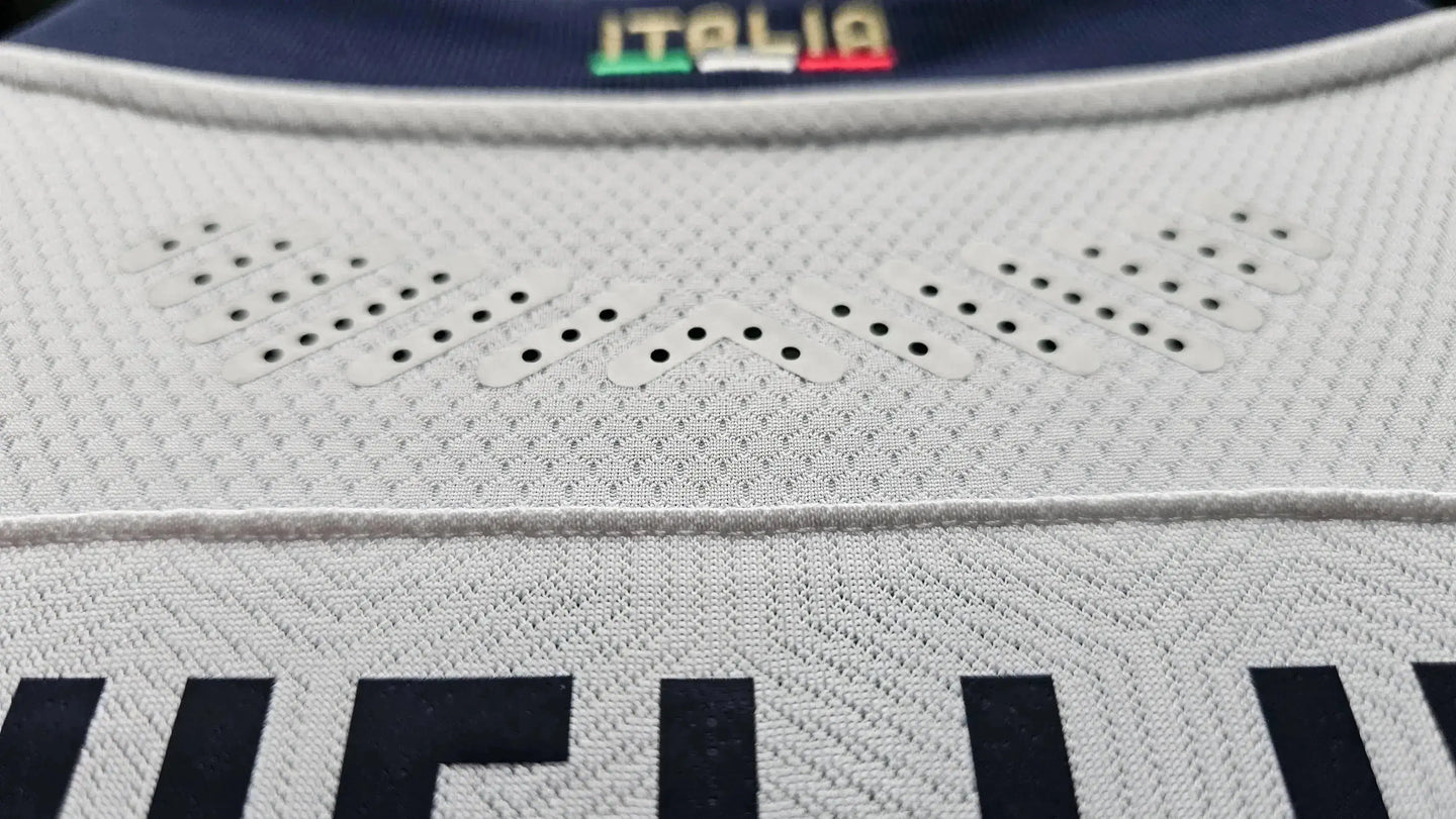 Detail view showing ventilation elements on the white fabric, neck labeled 'ITALIA'.