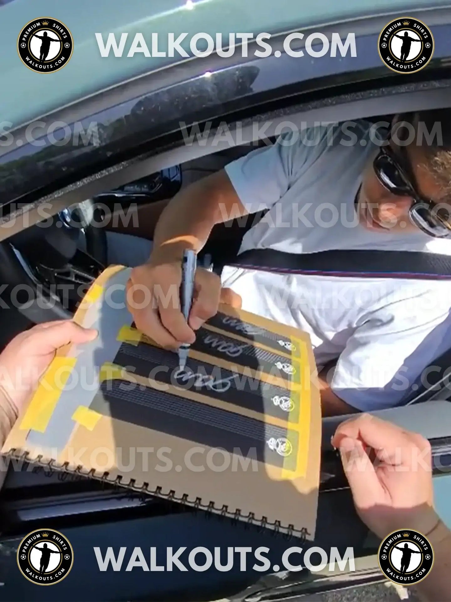 Gonzalo García signing with a marker on a notebook, featuring his signature and visible club crest colors.