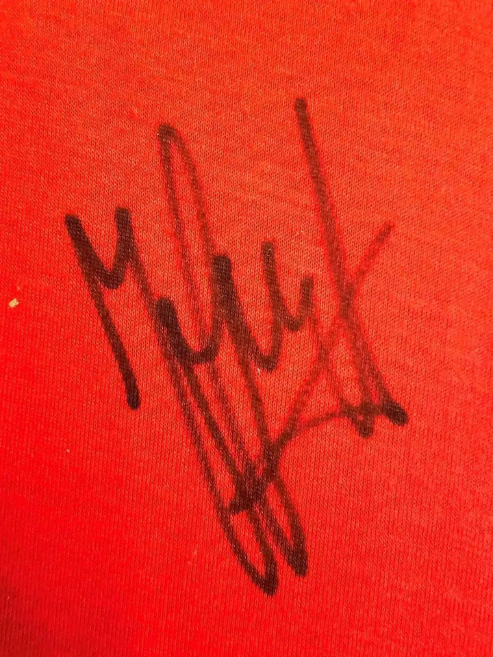 Signature detail of Johan Cruyff on a red background.